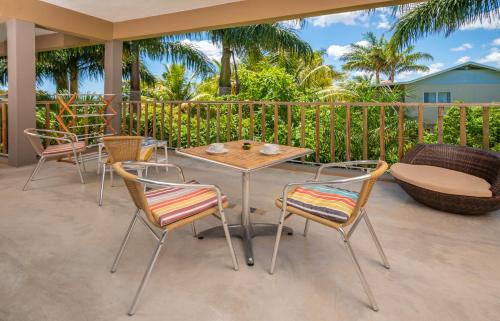 a patio with a table and chairs and a bench at The Rusty Pelican in La Gaulette