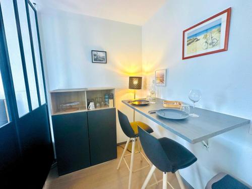 Cette chambre comprend un bureau avec des chaises et une table. dans l'établissement Studio 13 min plage - Parking - Ménage & Linge inclus, à La Rochelle