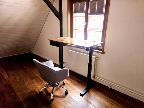 a desk and a chair in a room with a window at Chalet Happy Cow - Top Lage nähe Bodensee, Rheinfall, Schaffhausen & Zürich - Ländliche Idylle mit Privat-Parkplatz und viel Komfort - 120m2 - 3 Stockwerke in Ramsen