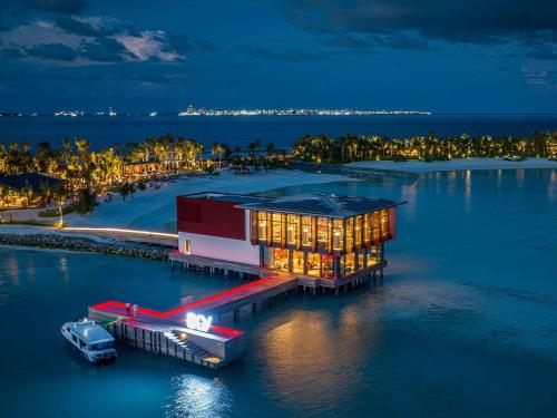 a rendering of a building on the water at night at SO/ Maldives in South Male Atoll