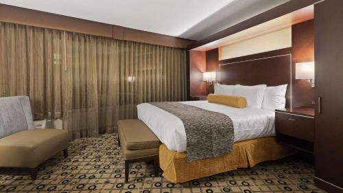 una habitación de hotel con una cama grande y una silla en Radisson Hotel Southfield-Detroit, en Southfield