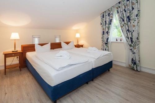 um quarto com uma cama com lençóis brancos e uma janela em Strand-Park Strand-Park V21 em Heringsdorf