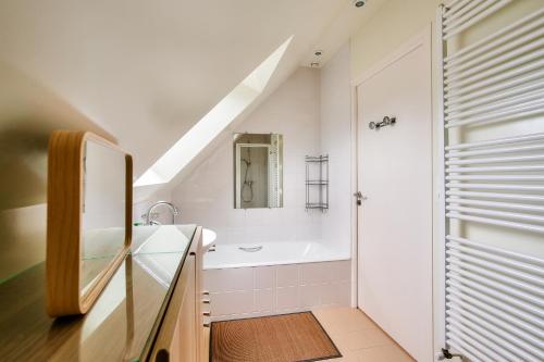 ein Badezimmer mit Waschbecken und Badewanne in der Unterkunft À 900m des plages- Maison pour 7 in Saint-Briac-sur-Mer