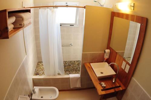 a bathroom with a shower and a toilet and a sink at Del Nomade Hosteria Ecologica in Puerto Pirámides