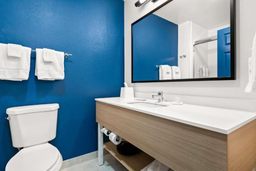 a bathroom with a toilet and a sink with a mirror at Spark by Hilton Lancaster Dutch Country in Lancaster