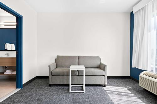 a living room with a couch and a stool at Spark by Hilton Lancaster Dutch Country in Lancaster