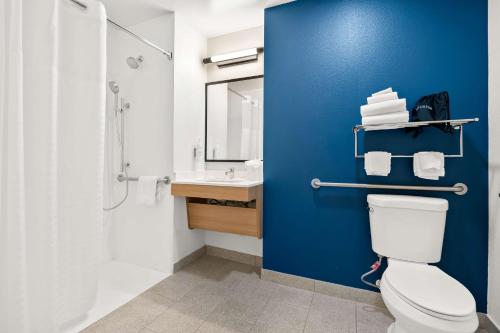Spark by Hilton Lancaster Dutch Country في لانكستر: حمام به مرحاض أبيض وجدار أزرق