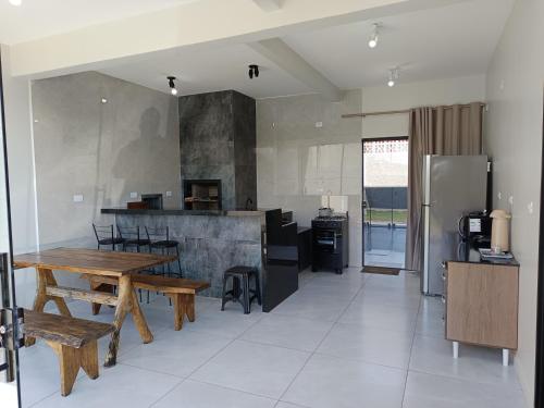 a kitchen with a wooden table and a refrigerator at Casa Gourmet Próx Marco Argentina Paraguai e Centro in Foz do Iguaçu