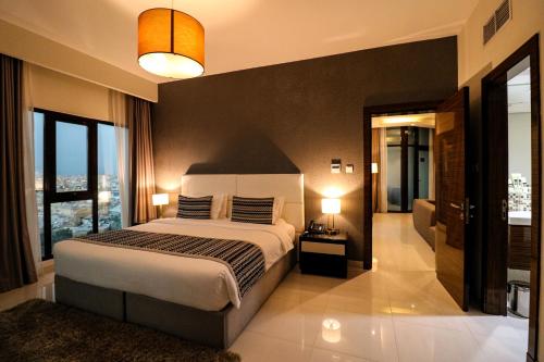 a bedroom with a large bed and a large window at Lagoona Beach Luxury Resort and Spa in Manama