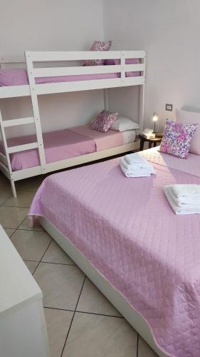 2 stapelbedden in een kamer met paarse lakens bij Il BorgoMct a Montecatini Terme in Montecatini Terme