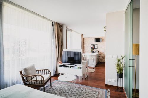 a living room with a bed and a television at Butique Apartman Grand in Balatonlelle