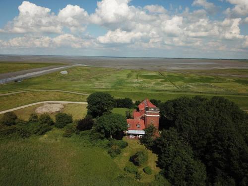 an aerial view of a house in a field at Ferienhaus Turm360, FeWo Vermittlung Nordsee, C Hüppeler in Varel