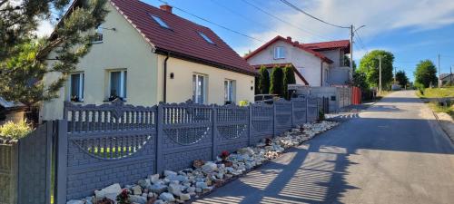 a fence in front of a house at Domek Przy Osadzie in Bieliny
