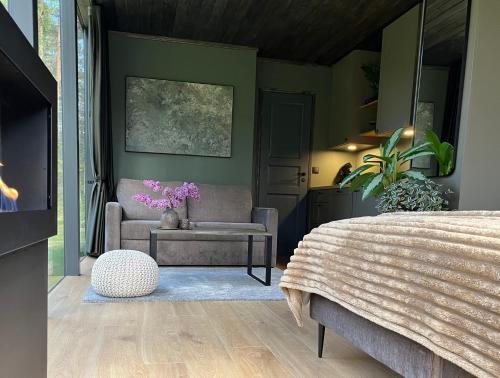 ein Schlafzimmer mit einem Bett, einem Sofa und einem Stuhl in der Unterkunft Mustika Mirror minivilla saunaga in Kärdla