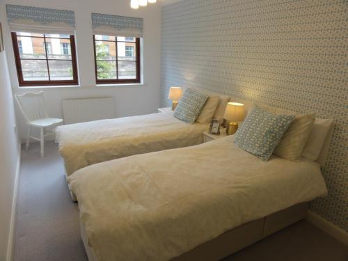 two beds in a room with two windows at Orchard Brae in Edinburgh