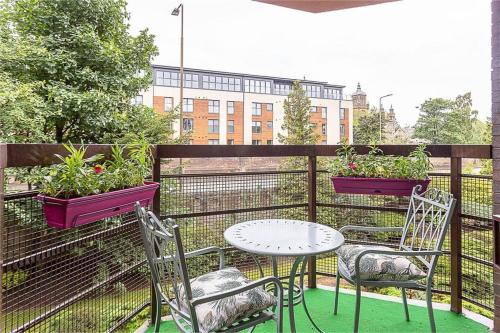 a balcony with a table and chairs and potted plants at Orchard Brae in Edinburgh