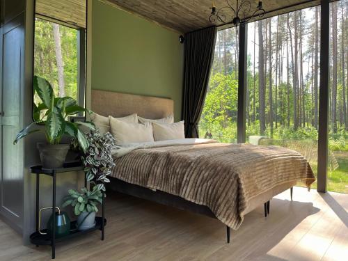 a bedroom with a bed with a large window at Mustika Mirror minivilla saunaga in Kärdla