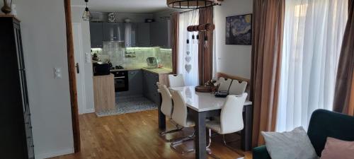 kuchnia i jadalnia ze stołem i krzesłami w obiekcie Domek Przy Osadzie w mieście Bieliny
