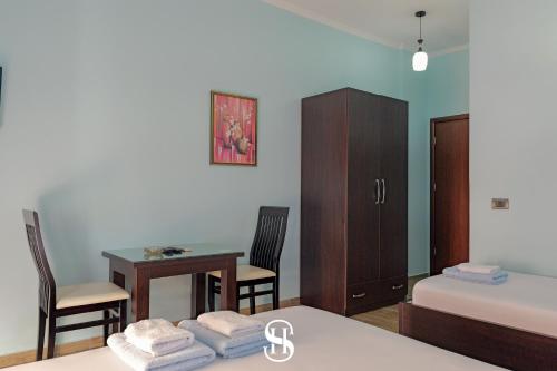 a bedroom with a bed and a desk and a table at Hotel SALA in Sarandë