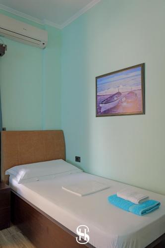 a bed in a room with a picture on the wall at Hotel SALA in Sarandë