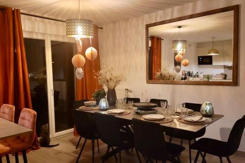 - une salle à manger avec une table, des chaises et un miroir dans l'établissement Maison familiale et cosy - Entre lac et montagne, à Doussard