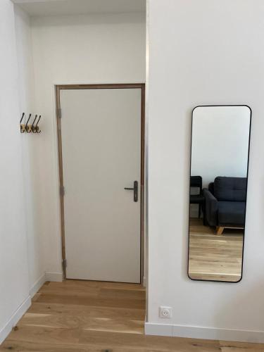 un miroir à côté d'une porte avec un canapé dans une pièce dans l'établissement Appartement Bonne Nouvelle, à Paris