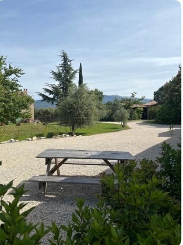 a wooden picnic table sitting on a gravel road at Appartement neuf Bédoin - Les Cinglés du Mont Ventoux in Mormoiron