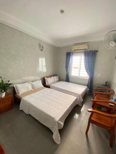 a bedroom with two beds and a window at HAI DANG HOTEL in Xóm Ðé