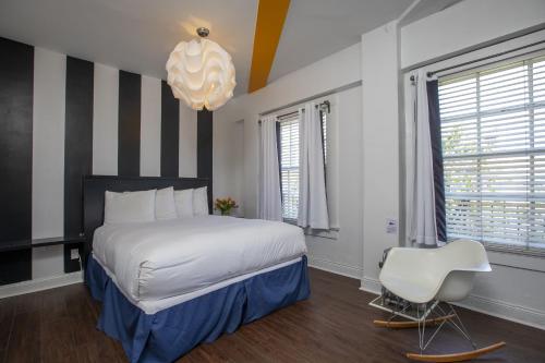 a bedroom with a large bed and a white chair at Edwardian Hotel in San Francisco