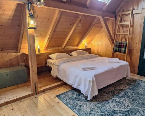 a bedroom with a large bed in a attic at Căsuța cu Prispă in Sîncraiu