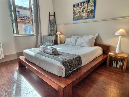 - une chambre avec un grand lit et une plate-forme en bois dans l'établissement La Maison des 2 Ponts Clim Centre, à Albi