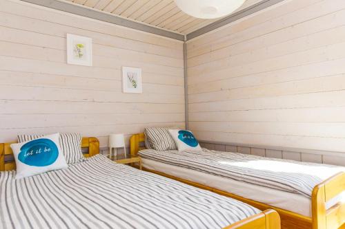 Dos camas en una habitación con paredes blancas. en Surf Domki Habenda z sauną ogrodową, en Sarbsk