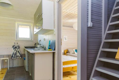 Casa pequeña con cocina y dormitorio en Surf Domki Habenda z sauną ogrodową, en Sarbsk