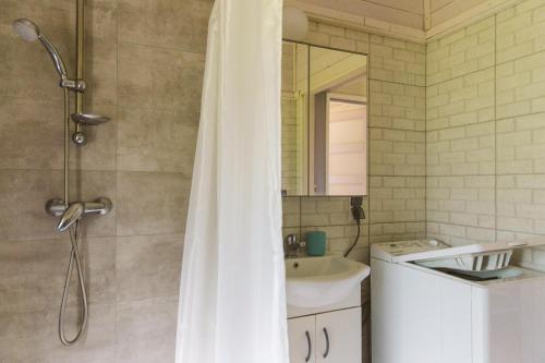 a bathroom with a shower and a sink at Surf Domki Habenda z sauną ogrodową in Sarbsk
