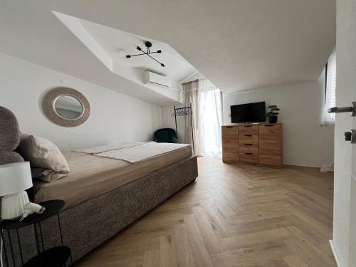 een slaapkamer met een groot bed en een televisie bij Apartment Mate in Seget Vranjica