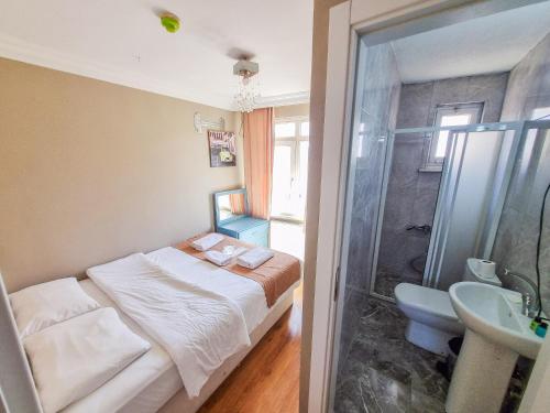 a bedroom with a bed and a bathroom with a shower at White Palace Büyükada in Adalar