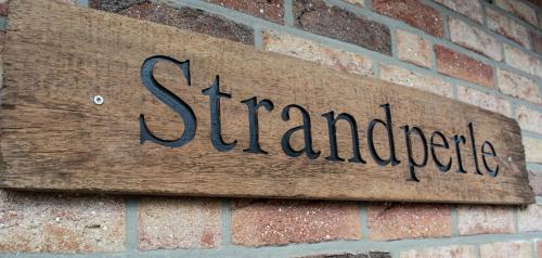 a sign on the side of a brick wall at Strandperle in Walchum