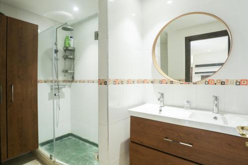 a bathroom with a shower and a sink and a mirror at At Casablanca 's Home in Casablanca