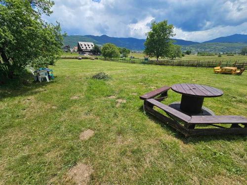 a picnic table in the middle of a field at Plav Lake Camping in Plav