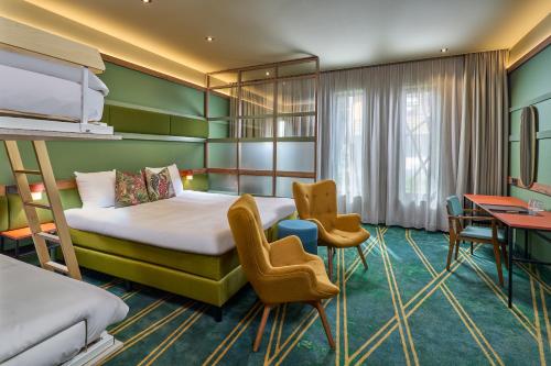 una camera d'albergo con letto, sedie e scrivania di Hotel Restaurant Grandcafé 't Voorhuys a Emmeloord