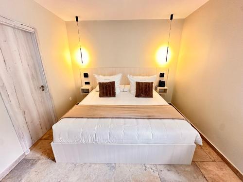 1 dormitorio con 1 cama blanca grande y 2 almohadas en AlliOli Boutique Hotel Spa en Castelló d'Empúries