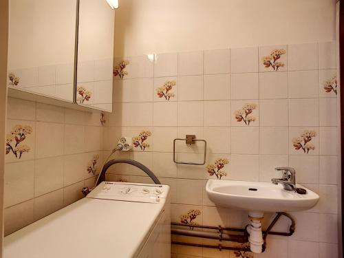 une salle de bain blanche avec un lavabo et un miroir dans l'établissement Chavanne - appartement - 4pers- Ski-inout, aux Gets