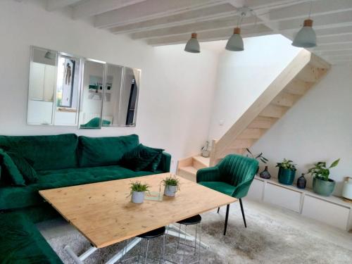 - un salon avec un canapé vert et une table en bois dans l'établissement MAISON ATYPIQUE EN BOIS 2 NIVEAUX 7,5km du circuit 24h, au Mans