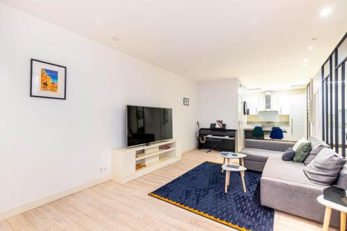 un salon avec un canapé et une télévision dans l'établissement GuestReady - Modern stay near Place de la Bastille, à Paris