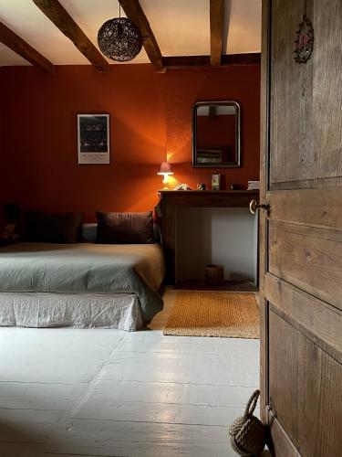 - une chambre avec un lit, un miroir et une porte dans l'établissement Au domaine d'Alice, à Saint-Laurent-sur-Gorre