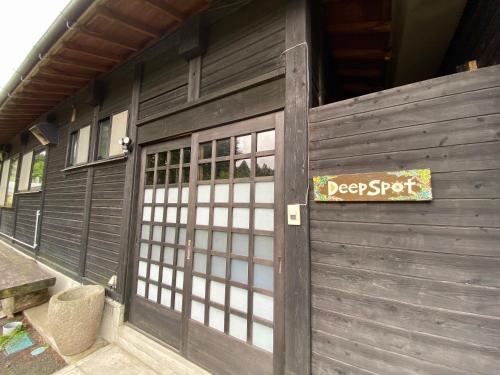 a garage door with a sign that reads deep spot at 黒川温泉から車で10分、阿蘇一望の貸切サウナ&一棟貸切宿【Deepspot】 in Minamioguni