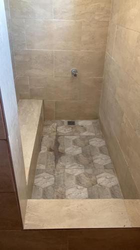 een badkamer met een douche en een tegelvloer bij BridgeView Arcadia in Portmore