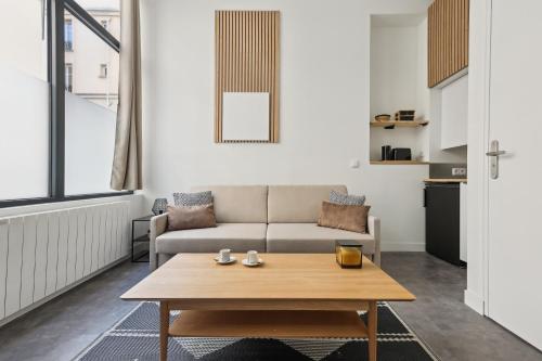 un salon avec un canapé et une table dans l'établissement Studio de Charme au Cœur de Paris!, à Paris