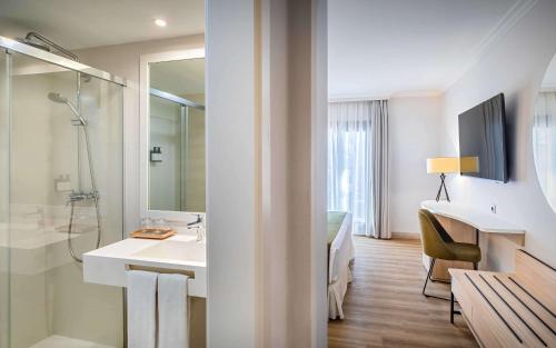 a white bathroom with a sink and a shower at Barceló Isla Canela in Isla Canela