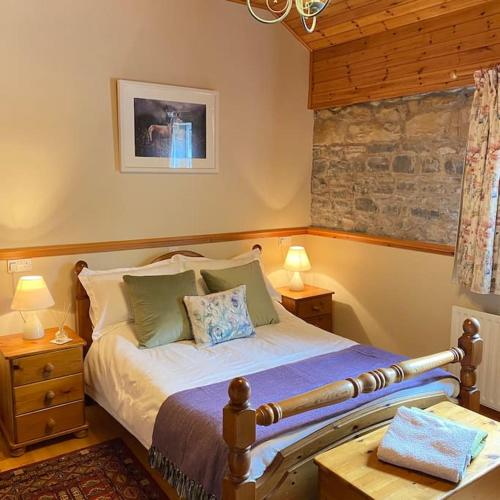 a bedroom with a bed with two tables and two lamps at Derryvree Farm Cottage in Maguires Bridge